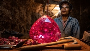 Myanmar officials examine a massive rough ruby discovered in Mogok, highlighting the scale of the 11,000-carat gemstone.