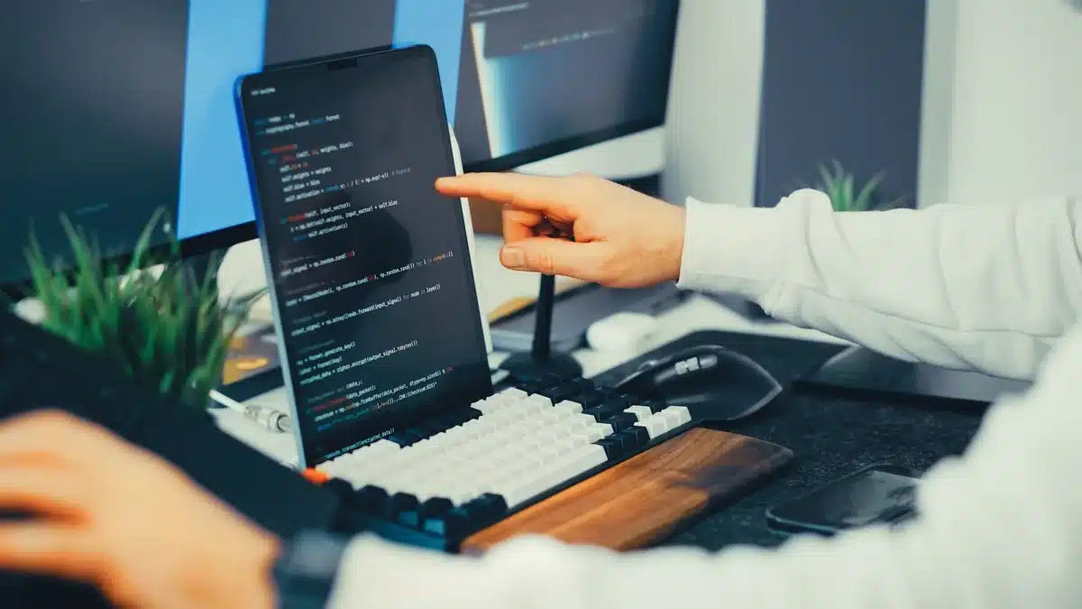 Hands typing at keyboard with glowing AI interface above a modern office desk