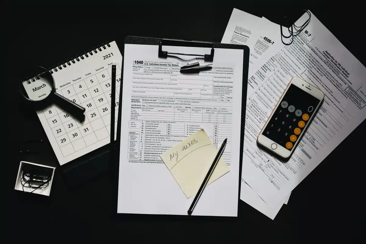 Tax documents and calculator on desk with December 2026 calendar marking the Opportunity Zone deferral deadline