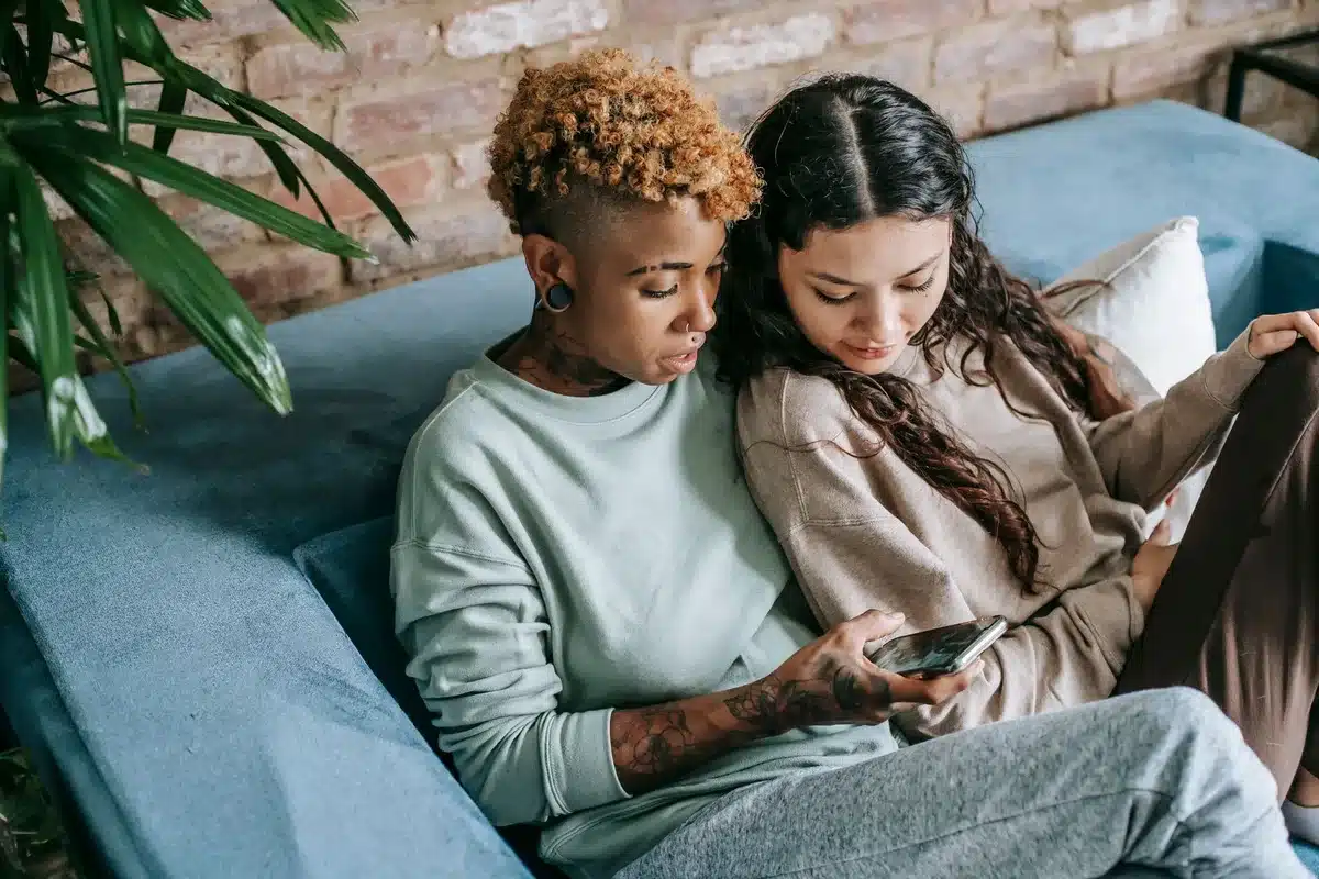 Persona navegando en redes sociales con expresión de ansiedad mientras está en una relación