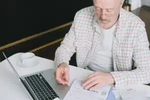 Medical bills, insurance documents, and a calculator on a table representing healthcare cost planning