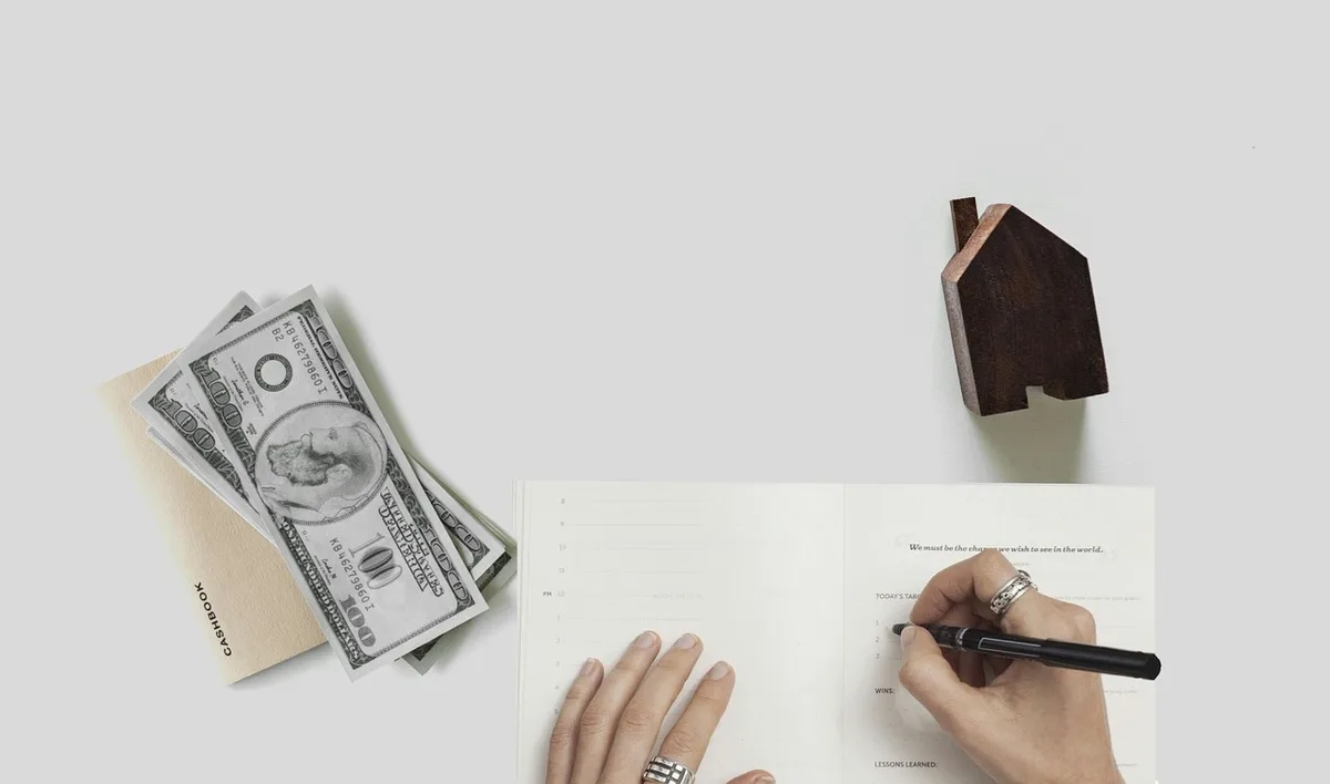 Prospective homebuyer reviewing mortgage paperwork and housing costs at desk