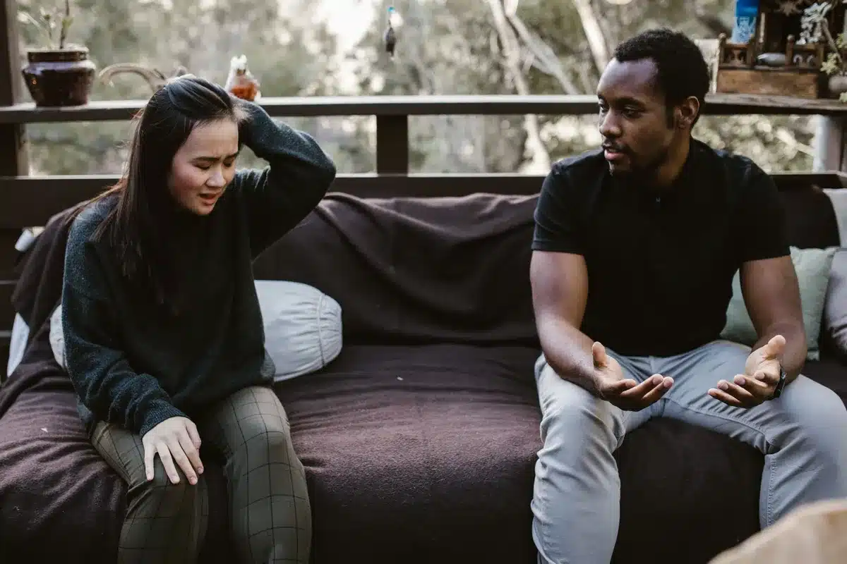 A woman listening to a man speak, her expression showing boredom or skepticism.