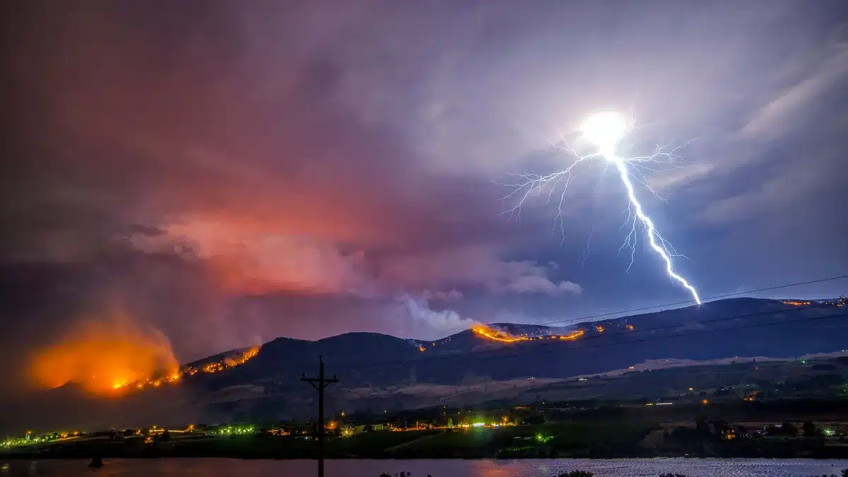 Powerful lightning bolts striking within dark volcanic ash clouds