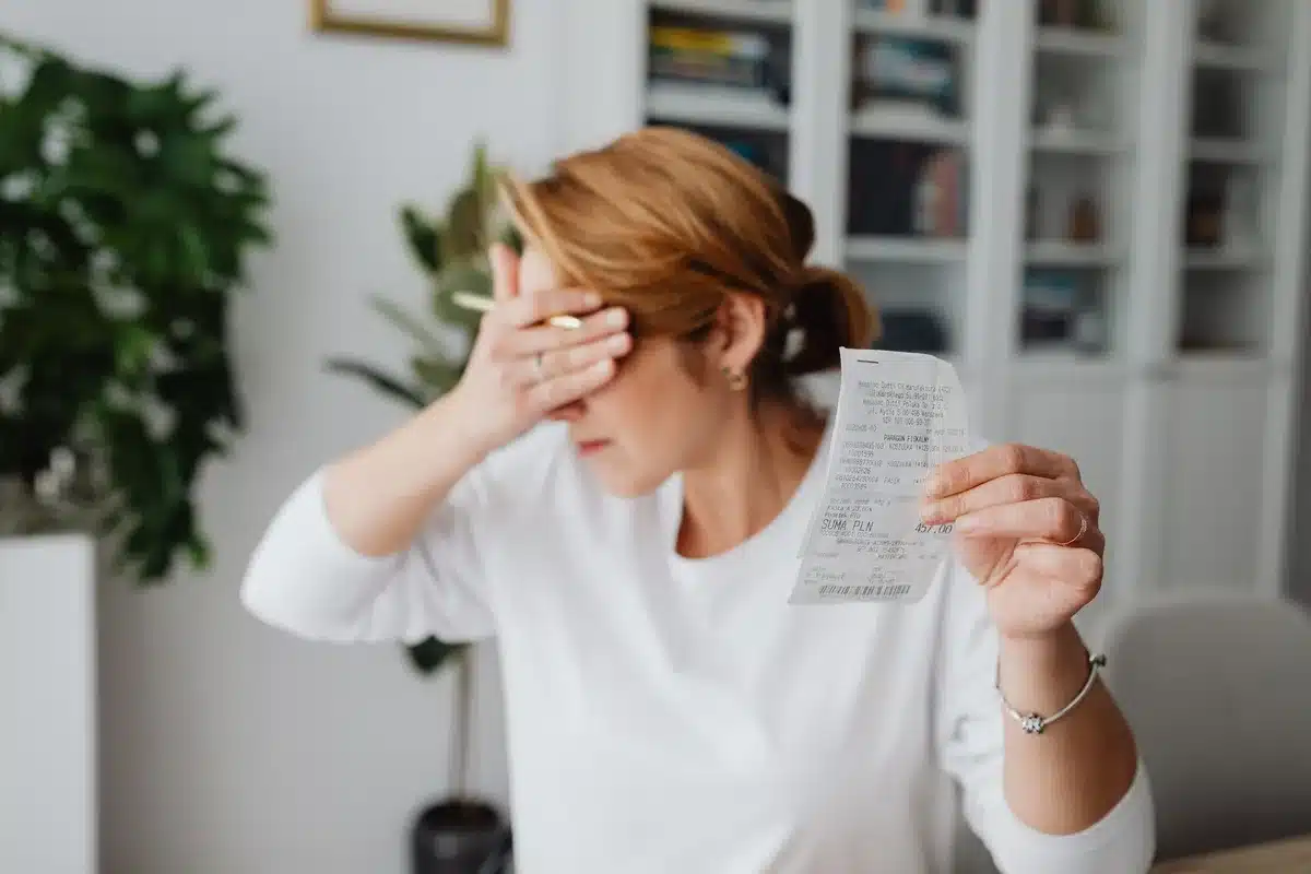 Leeres Portemonnaie neben Rechnungen und Quittungen auf einem Schreibtisch