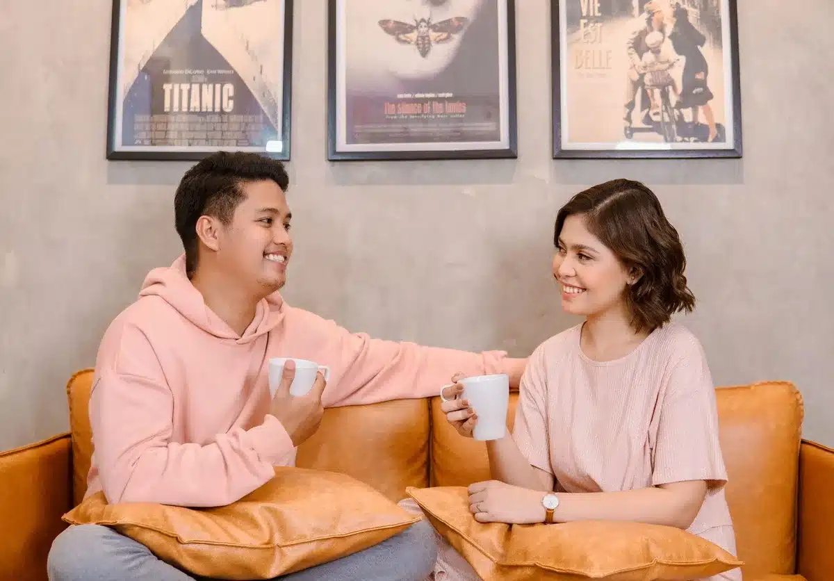 A couple sitting close together on a couch, relaxed and engaged in conversation