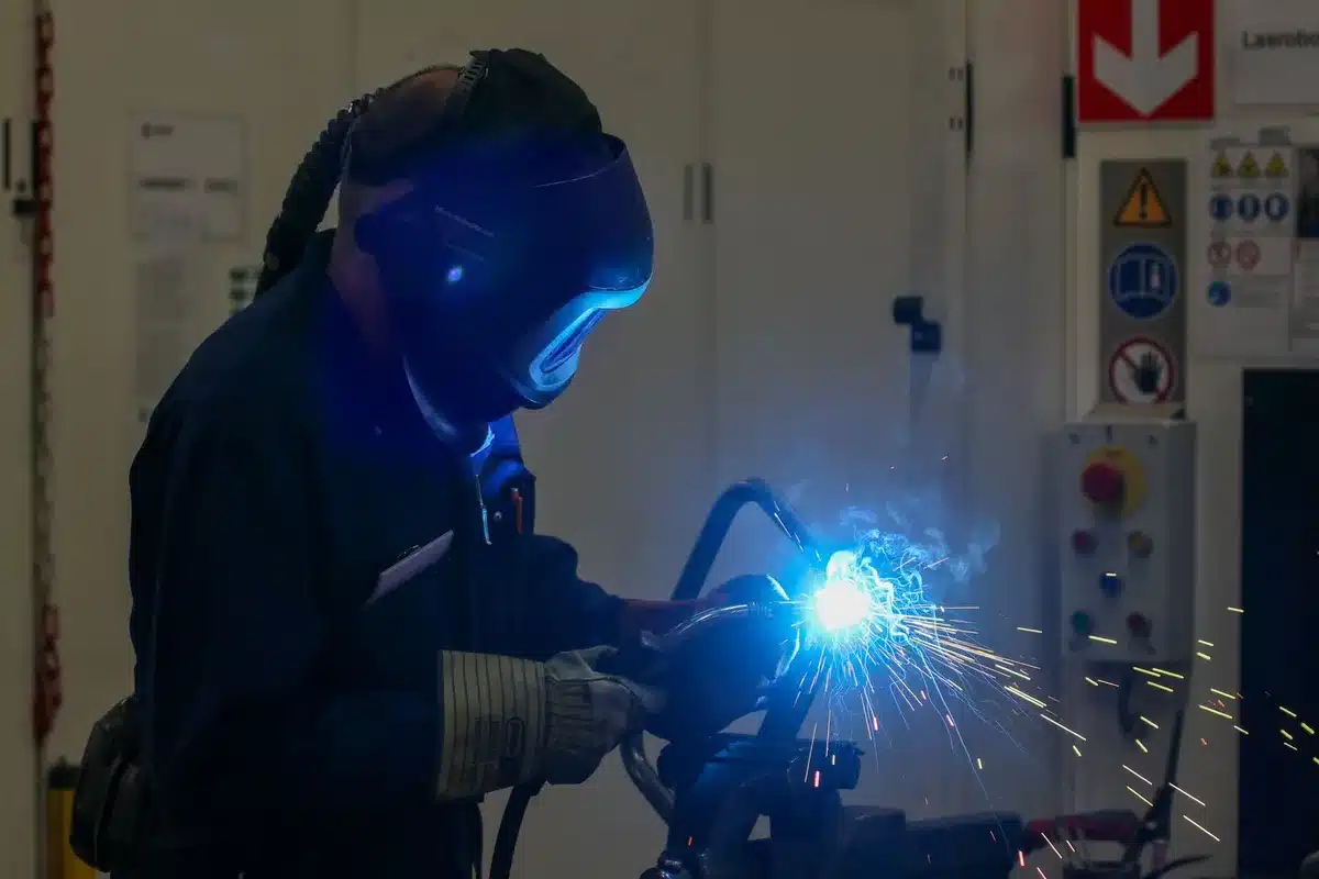 Worker in safety gear using hand tools on an active construction or industrial site