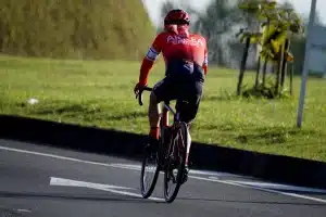 Race official inspecting a cyclist's jersey and chest area before a time trial competition