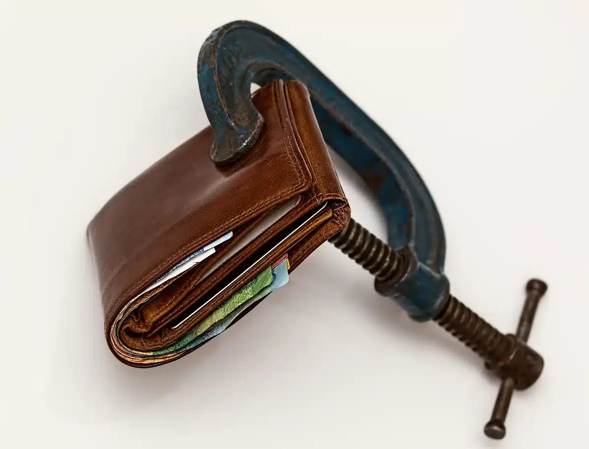 Anonymous person reviewing bills and expenses, illustrating financial pressure on household budgets.