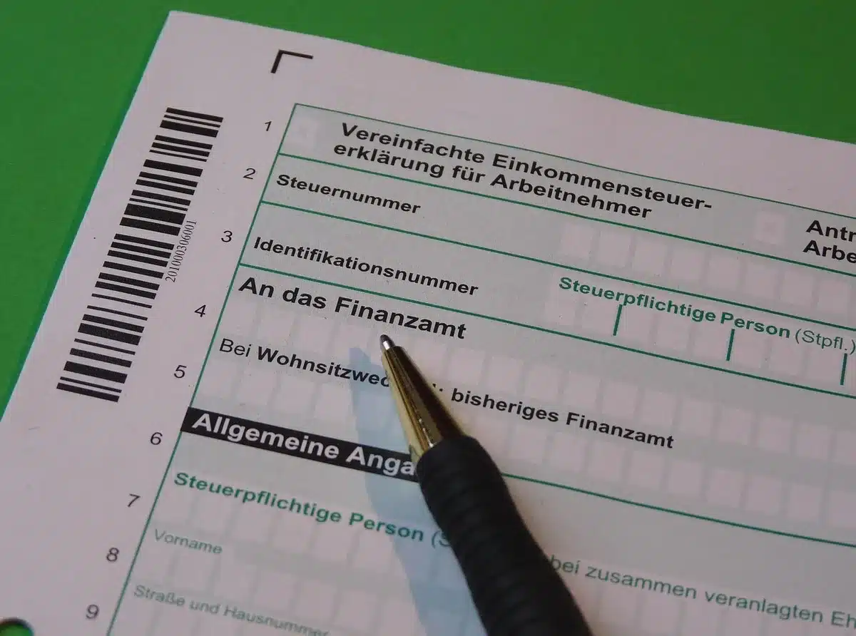 Hands holding overdue tax notice with financial documents and bills on desk