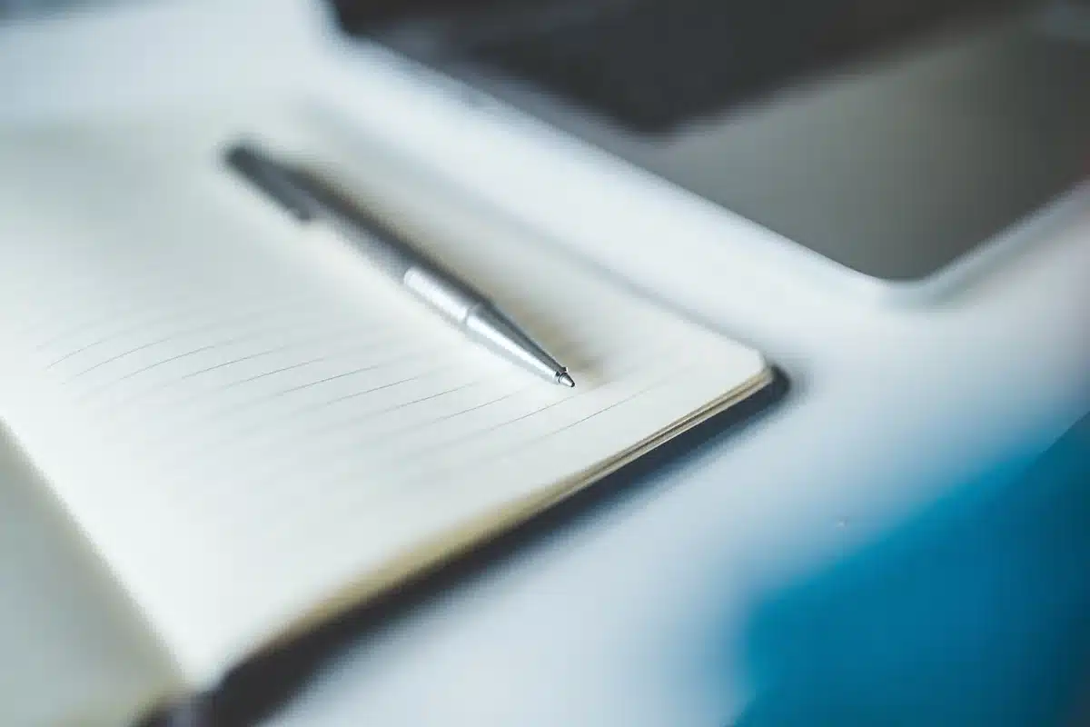 Main anonymous hand writing priorities on a notepad to define partner goals