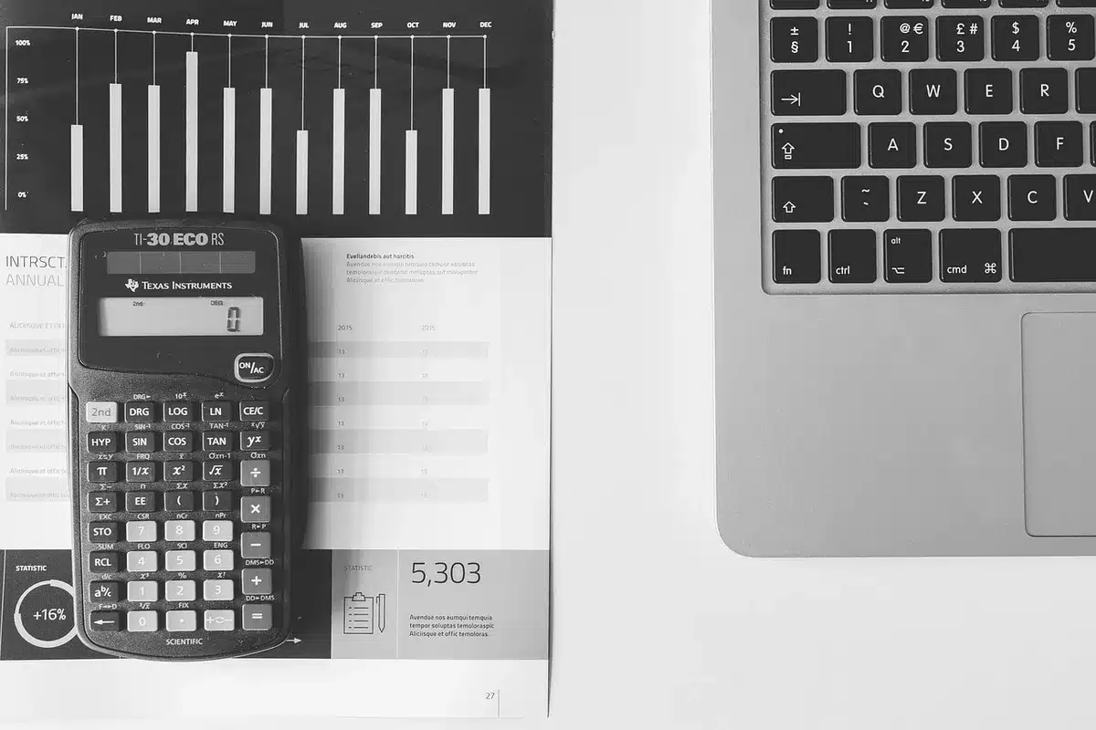 Investor reviewing accounts on a laptop with a calculator nearby