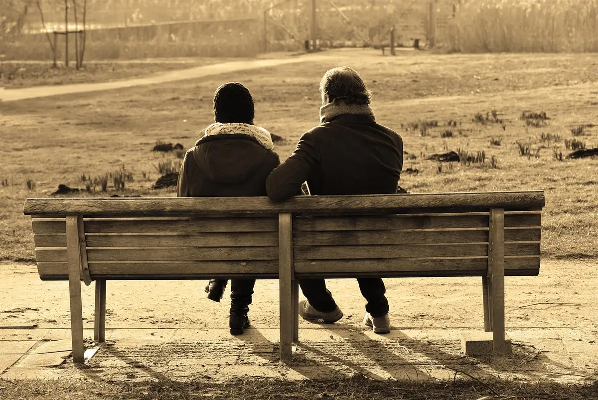 Pareja en conversación tranquila y abierta, sentados frente a frente en un ambiente relajado