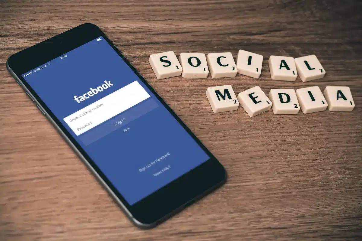 Hands holding a phone displaying social media, showing likes and comments on content