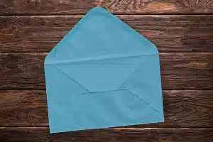 Anonymous hands sorting bills and an envelope on a kitchen table