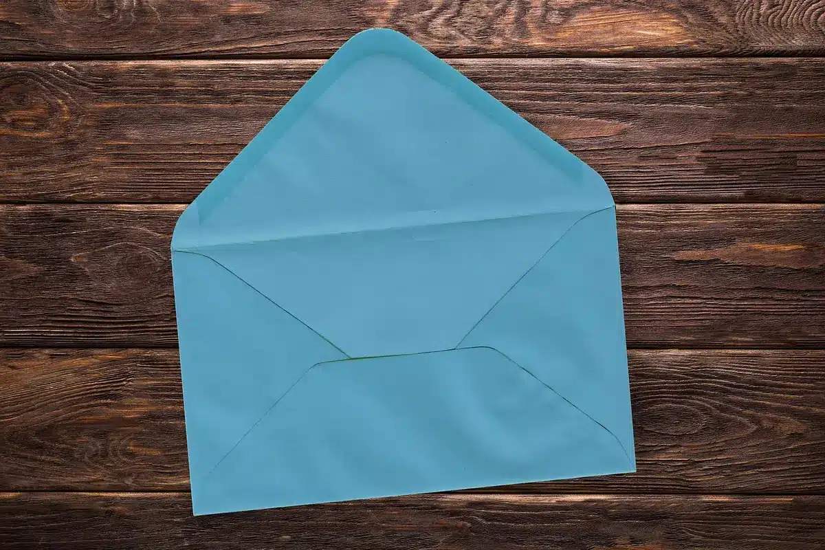 Anonymous hands sorting bills and an envelope on a kitchen table