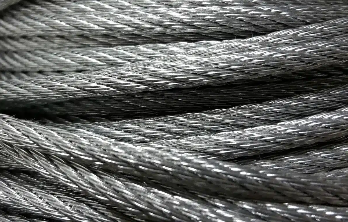 Unbranded metal coils and pallets at a warehouse loading dock, silhouetted truck in background