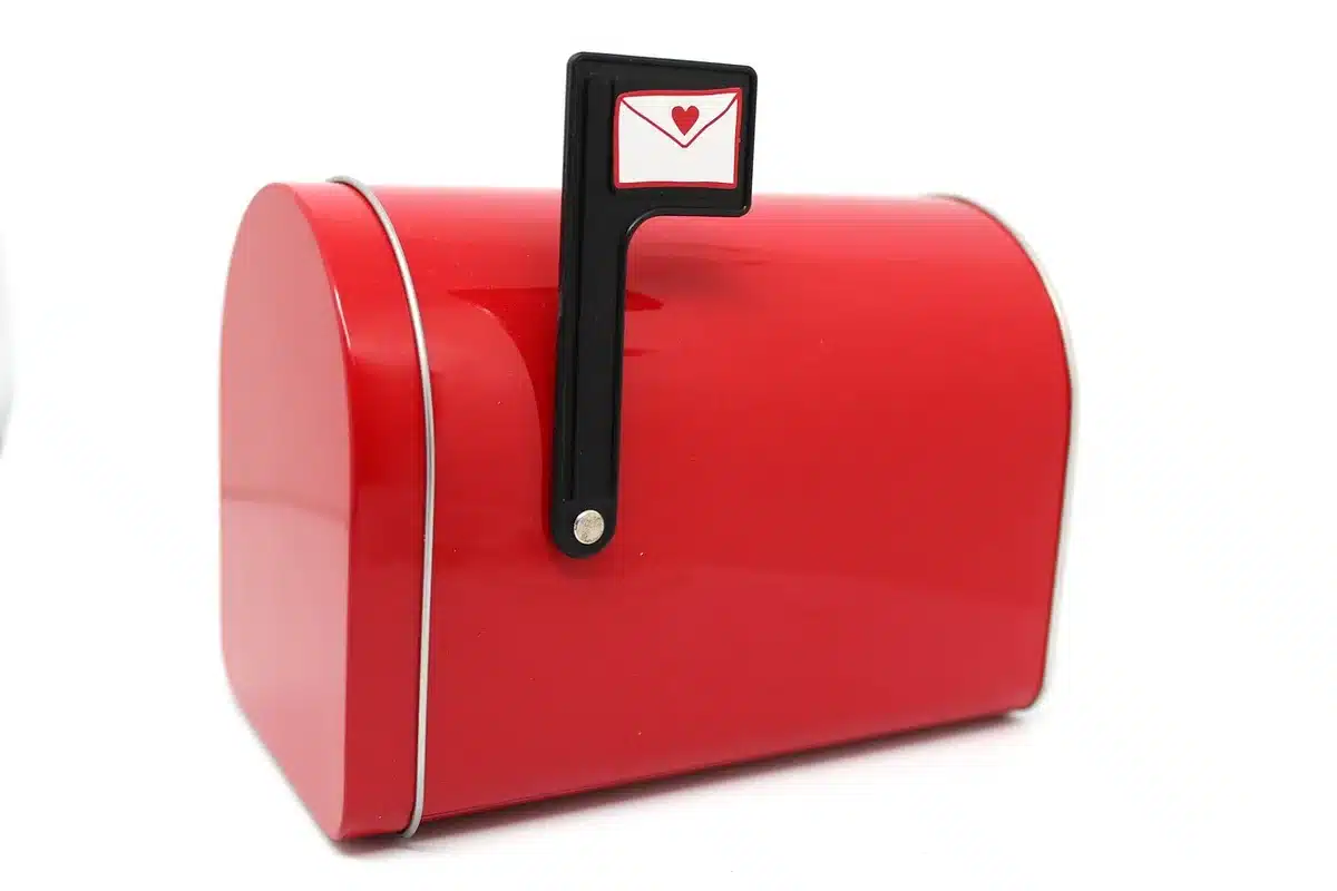 Person holding ACA enrollment paperwork next to a mailbox