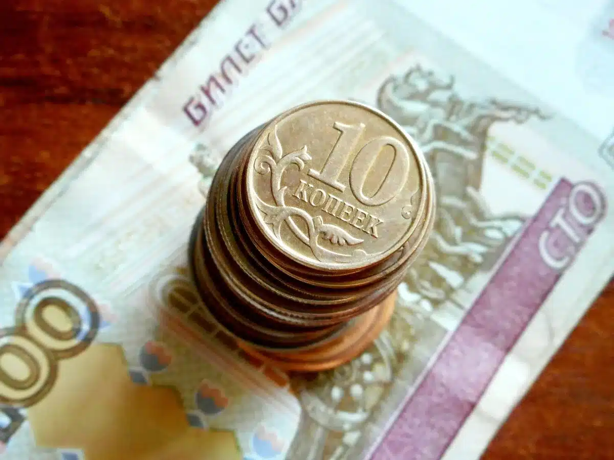 Hand holding a few pennies over a table