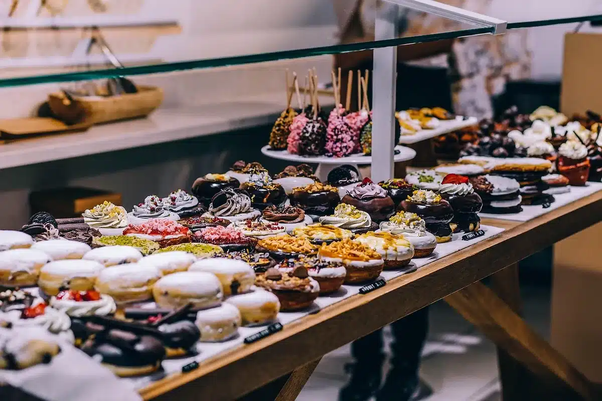 Glazed donut in a display case with a small anonymous rodent silhouette nearby in a shopping mall