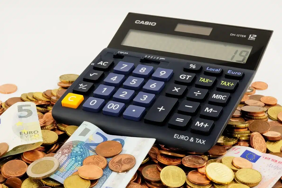 Tax preparer reviewing pay stubs and W-2 at a desk with calculator