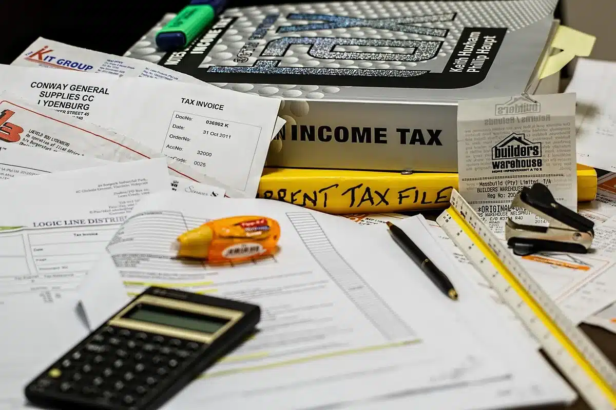 Stack of audit documents and a government report on a desk
